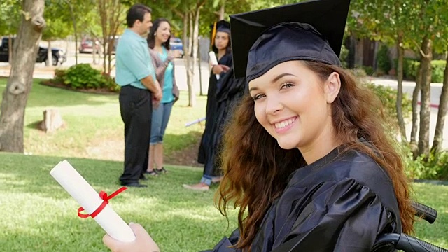 美丽的大学毕业生在轮椅上骄傲地拿着她的文凭视频下载