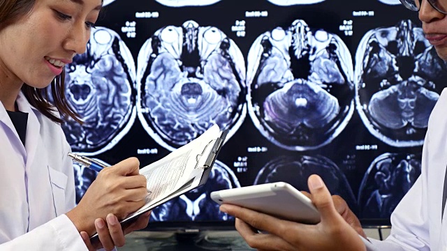 两位医生在数字平板电脑上讨论核磁共振扫描视频素材