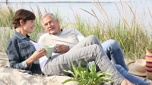 一对老年夫妇在海滩上休息视频素材