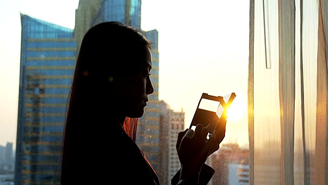 女商人使用手机剪影场景。视频素材