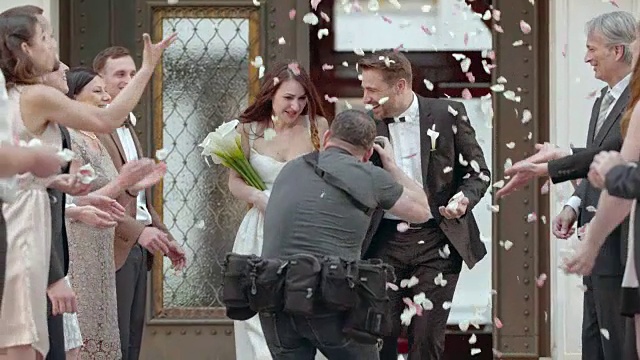 SLO MO摄影师拍摄新婚夫妇离开教堂的照片视频素材