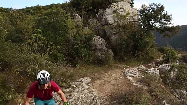 山地车攀登岩石崖壁以上的道路和山谷视频素材