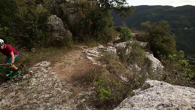 山地车攀登岩石崖壁以上的道路和山谷视频素材