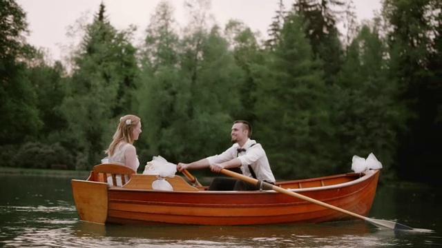 SLO MO新娘和新郎在湖上划船视频素材