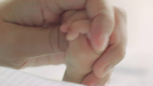 新生儿抓住妈妈的手指视频素材