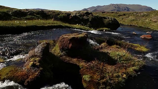 宽镜头的河流流经山谷与岩石山的背景视频素材