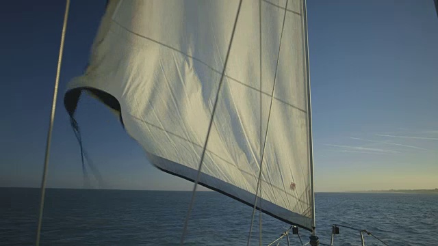 手持式拍摄的帆，因为它是卷起在一个移动的游艇离开英格兰，英国的南海岸。视频素材