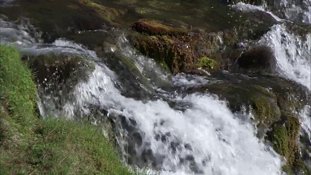 瀑布在长满苔藓的岩石上的特写镜头视频素材