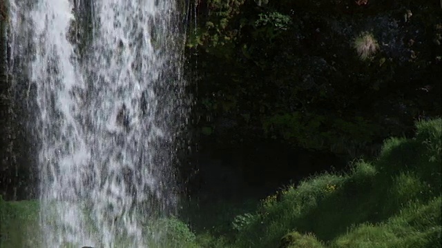 瀑布和长满苔藓的岩石的中等镜头视频素材