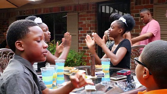 潘小姐两姐妹在后院聚会上与家人和朋友玩拍手游戏视频素材