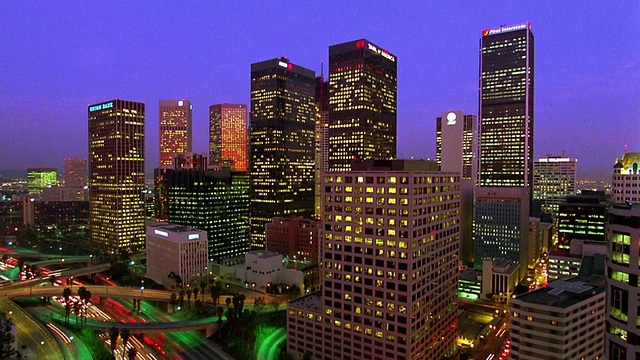 宽镜头延时办公大楼在夜间与交通高速公路在前景/洛杉矶，加利福尼亚视频素材