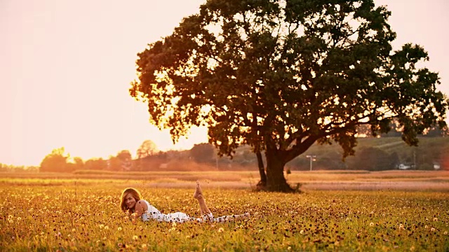 日落时分躺在草地上的女人视频下载