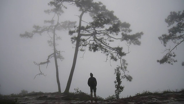 一个徒步旅行者在山顶伸展手臂视频素材
