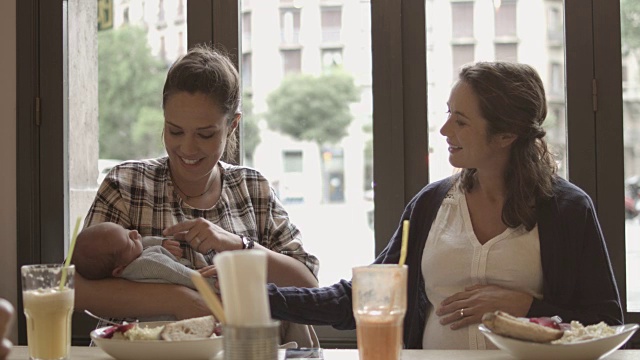 带着婴儿的女人在咖啡馆里和怀孕的朋友聊天视频下载