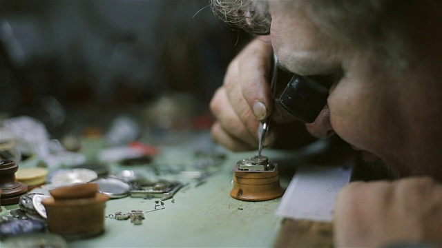 钟表匠正在修理和维护一台自动机械表，修理和检查钟摆视频素材