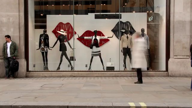 购物者快速地从牛津街的时装橱窗前走过视频下载