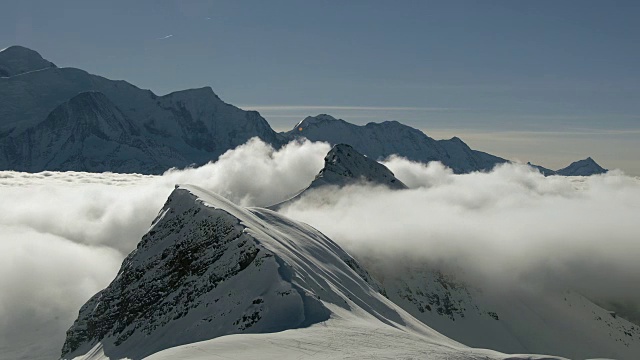在法国阿尔卑斯山脉的豪特萨伏伊地区，一团逆温云在积雪覆盖的山脊上形成并经过视频下载