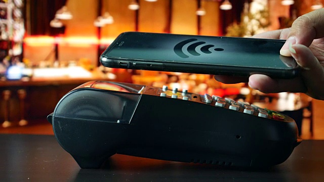 使用智能手机在餐厅进行非接触式支付，采用NFC技术支付视频下载