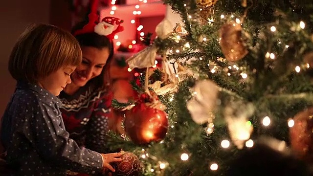 母亲和儿子在圣诞树旁等待圣诞老人视频下载