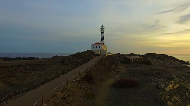 在地中海沿岸，日出时，无人机在梅诺卡岛北岸的法瓦利克斯灯塔上拍摄的航拍画面。4 k UHD。视频下载