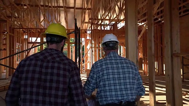 两名男子穿过一座正在施工的建筑视频素材