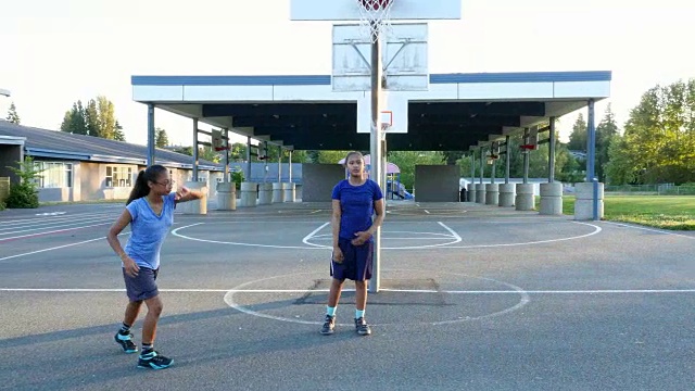 在夏天的晚上，姐妹们在室外打篮球视频素材