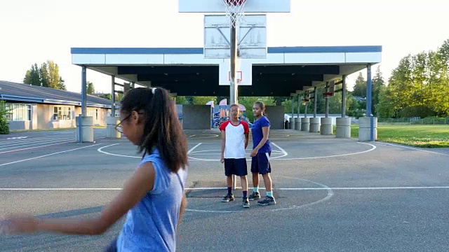 夏天的晚上，MS姐妹们在室外篮球场上练习跳投视频素材