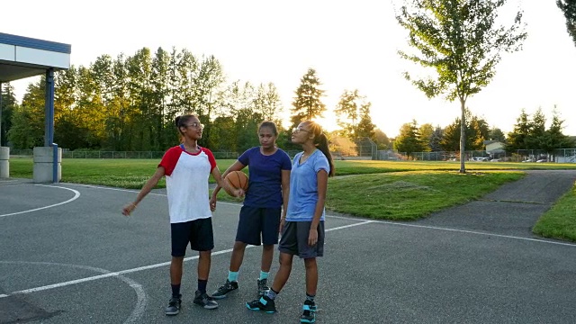 一个夏天的晚上，三姐妹打完篮球后在外面闲逛视频素材