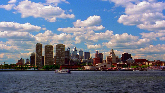宽镜头长镜头时间流逝云在蓝色的天空在费城天际线与特拉华河在前景/宾夕法尼亚视频素材