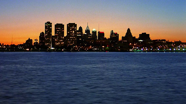 宽镜头长镜头时间推移剪影费城天际线在黄昏与特拉华河在前景/宾夕法尼亚视频素材