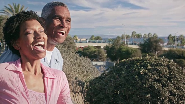 幸福的非洲裔美国夫妇在海滨木板路拥抱视频素材