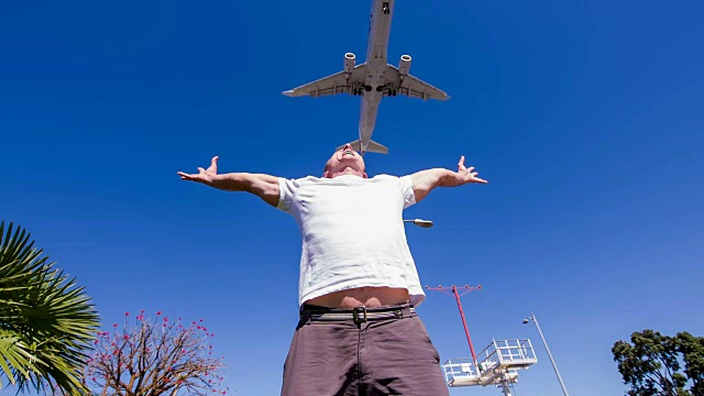 一架飞机在一个中年男子上空飞行视频下载