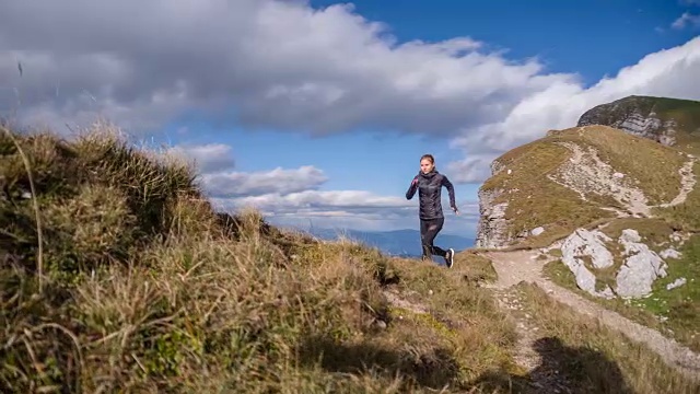 一个年轻女子在山脊上跑步视频素材
