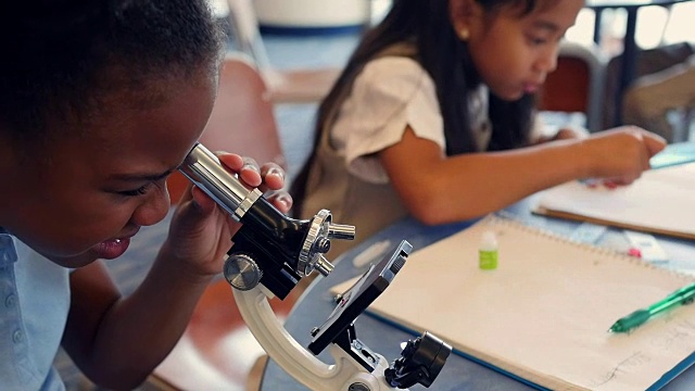 可爱的非裔美国STEM学校学生用显微镜检查东西视频素材