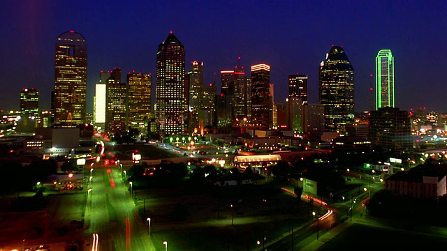 高角度广角拍摄时间推移交通与达拉斯天际线的背景在晚上/德克萨斯视频下载