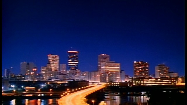 宽镜头延时闪电在明尼阿波利斯天际线与桥梁和密西西比河在前景在晚上/明尼苏达州视频下载