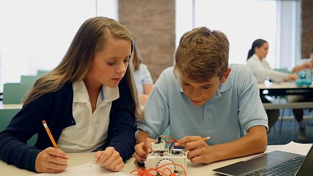 十几岁的男孩和女孩在技术课上一起做机器人项目视频素材