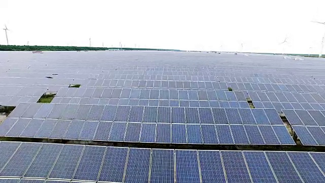 太阳能电池板附近的风力发电站俯视图视频下载