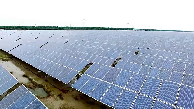 太阳能电池板附近的风力发电站俯视图视频下载