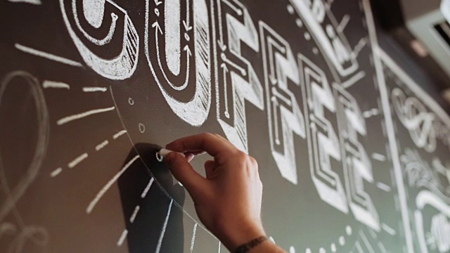 街头艺术家正在咖啡馆的黑色墙壁上用粉笔涂鸦视频下载