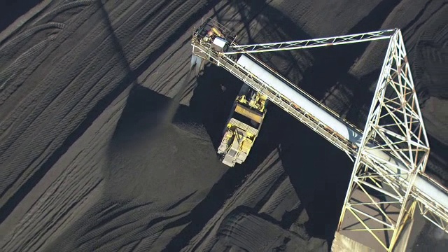 美国密歇根州阿尔佩纳水泥厂，一辆黄色卡车在煤堆旁行驶视频素材