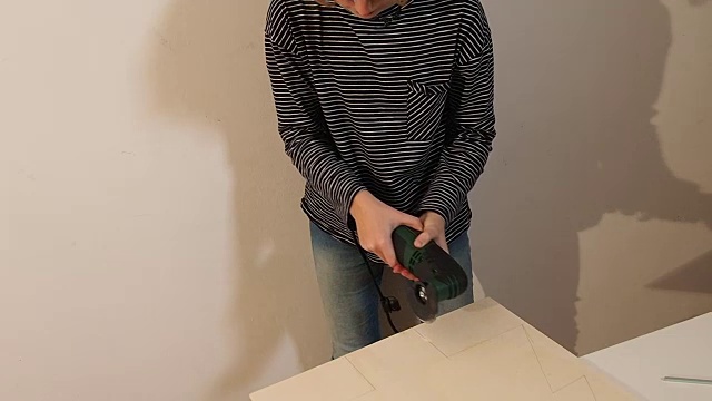 女孩(13-14岁)做手工艺品。她用电动机器切割木板。她戴着防护眼镜。太阳眼镜确实是。德国，欧洲的圣诞节视频素材