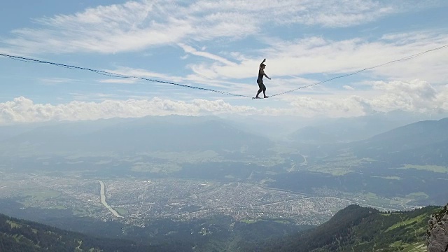 一名男子在阿尔卑斯山的高空绳索上松驰视频下载
