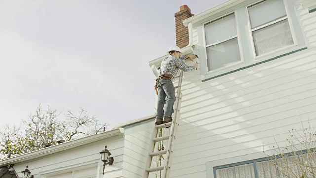 建筑工人爬上梯子，在住宅上干活视频素材
