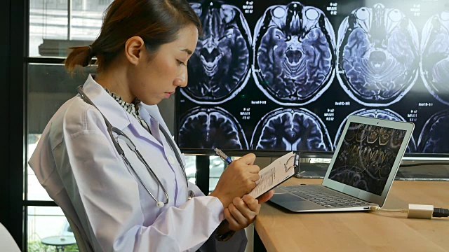 医生在数字平板电脑上看核磁共振扫描视频素材