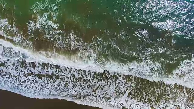 海浪在海滩溅水的鸟瞰图。视频素材