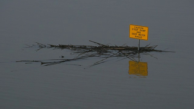 德克萨斯州达拉斯特拉梅尔克罗公园的三一河洪水几乎淹没了黄色标志视频素材