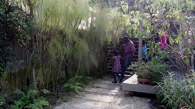 一个非裔美国家庭微笑着在花园里散步视频素材