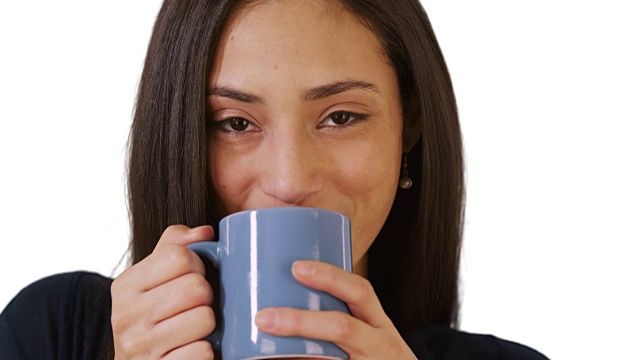 一个在白色背景上喝咖啡的西班牙妇女的特写视频素材