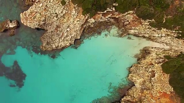 无人机拍摄的航拍镜头，在梅诺卡岛田园诗般的海滩上，美丽的绿松石色的水，没有人在一个和平的视野。4 k UHD。视频素材